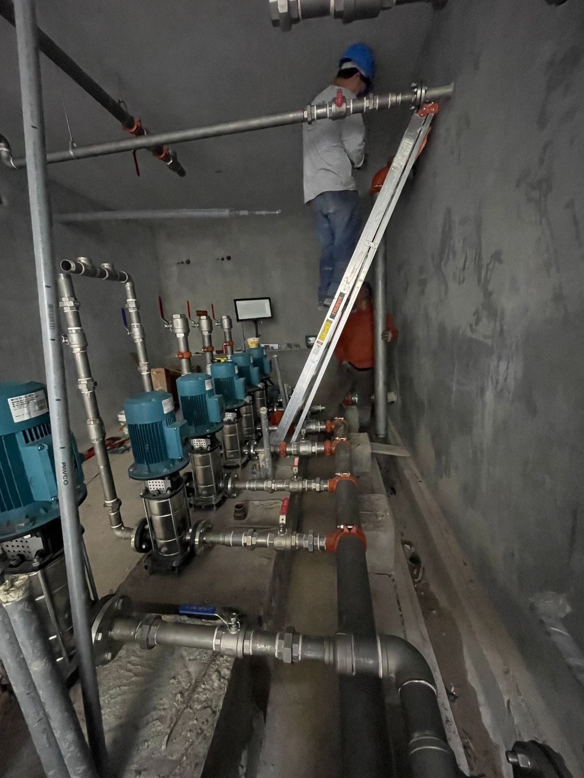 Equipo de TOOR montando la tubería de un cuarto de bombas
